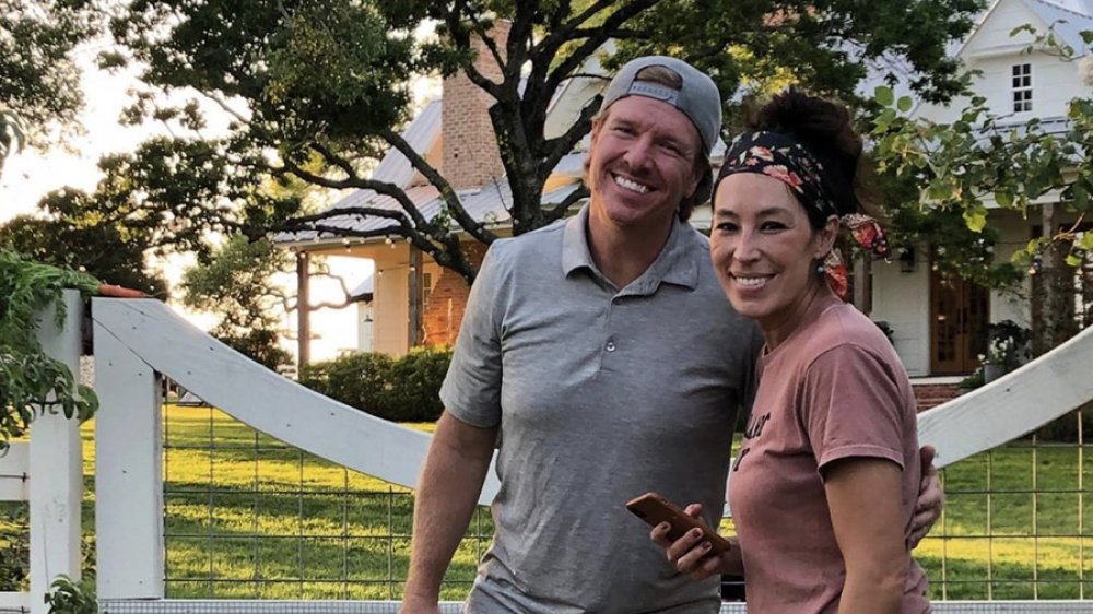 Fixer Upper's Chip Gaines and Joanna Gaines in the front yard of their home