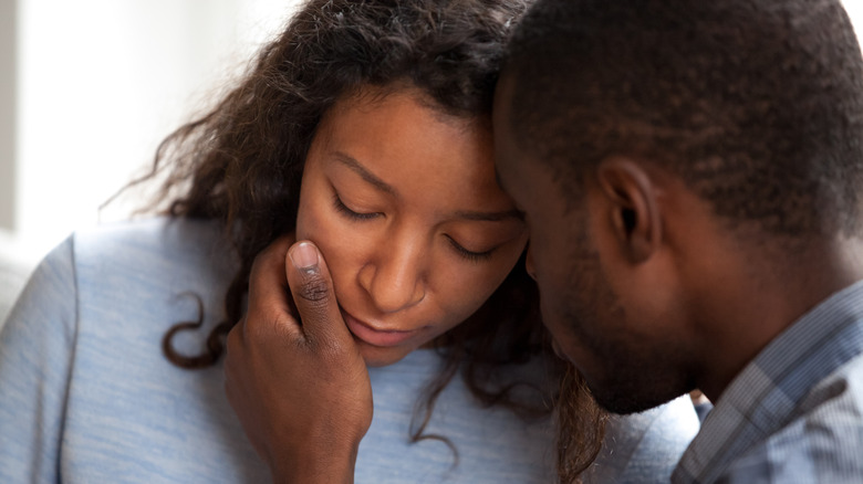 Man comforting sad woman