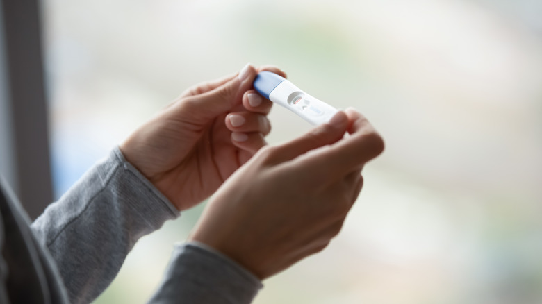 Woman holding a pregnancy test