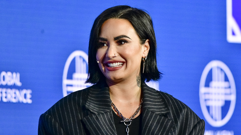 Demi Lovato smiling blue background