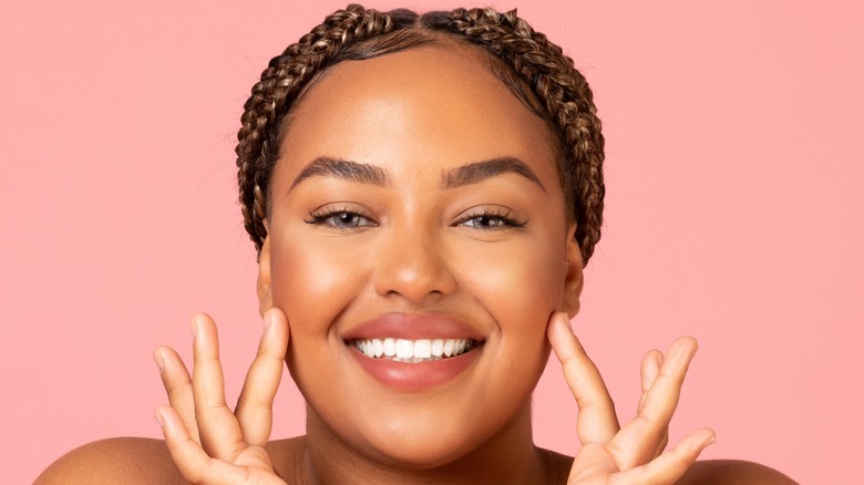 woman moisturizing face, applying moisturizer