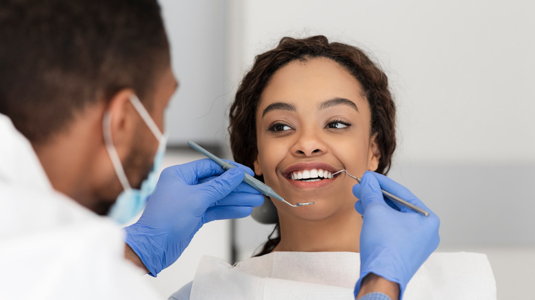 Dentist examines patient in chair 