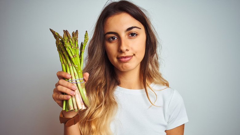 Woman holding bundle of asparagus