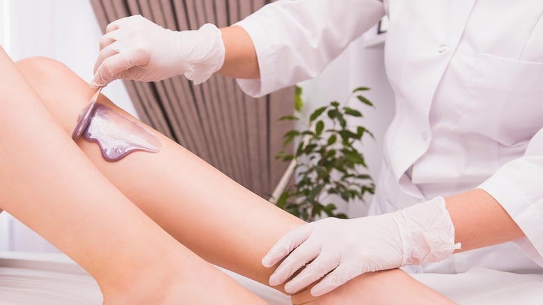 person getting legs waxed