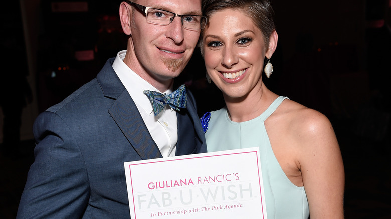 Man & woman holding Giuliana Rancic's Fab-U-Wish cert