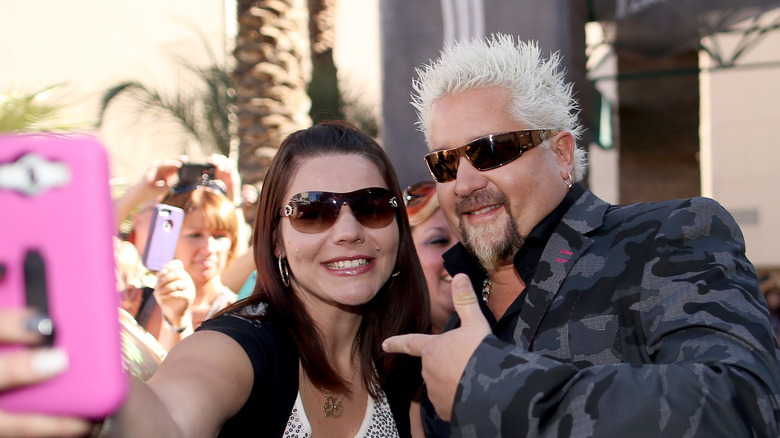 Guy Fieri taking photo with fan