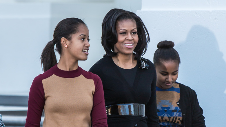 Michelle Obama smiling with her daughters