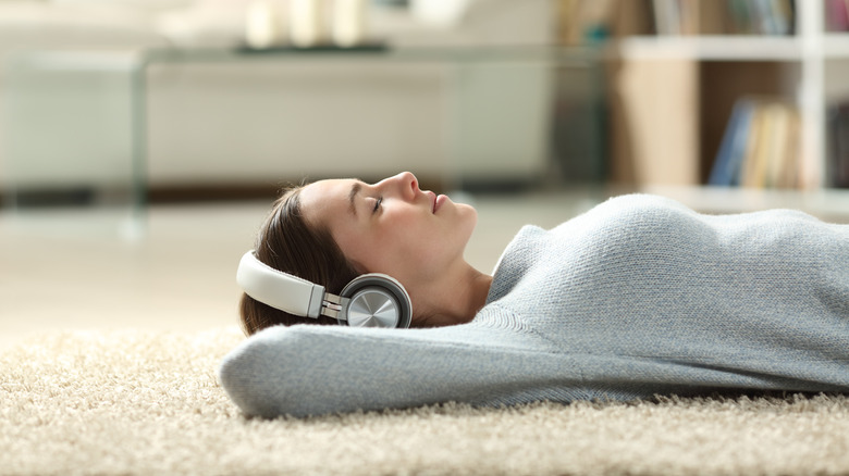 Woman using headphones on the floor