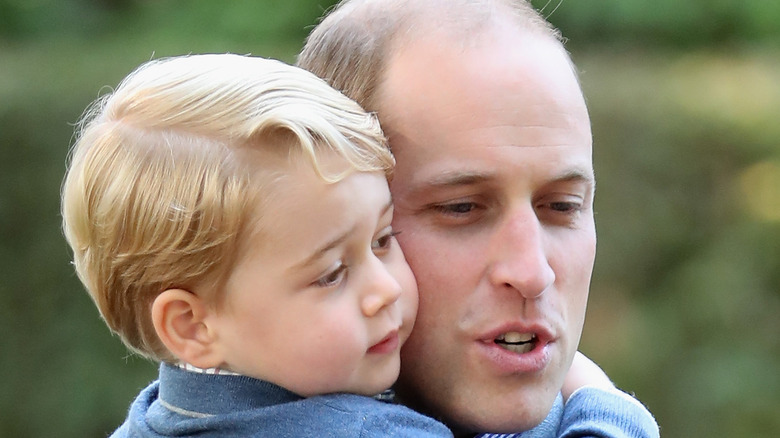 Prince William snuggles Prince George