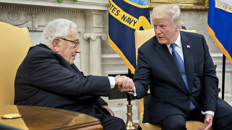 Henry Kissinger and Donald Trump shake hands