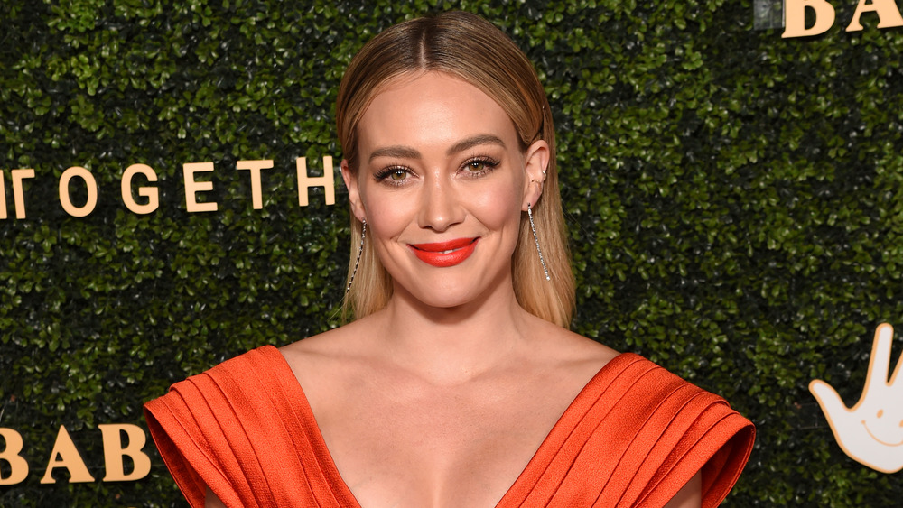 Hilary Duff in orange gown on red carpet