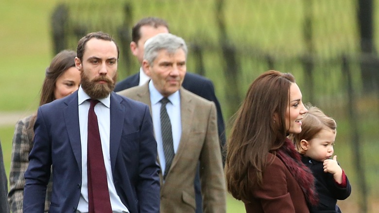 Pippa Middleton, Michael Middleton, James Middleton walking & Kate Middleton carrying Princess Charlotte