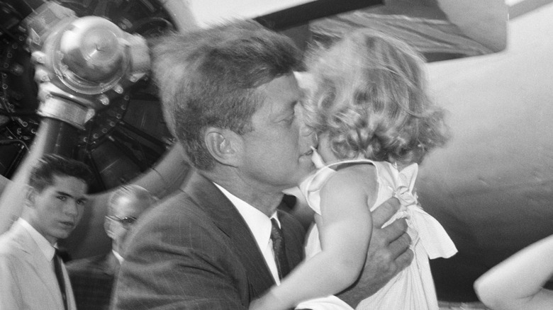 John F. Kennedy holding and kissing Carolyn Kennedy