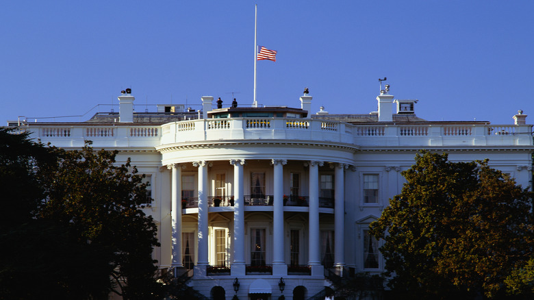 A view of the US Capitol, showing the flag flying above it only halfway raised on the flagpole.