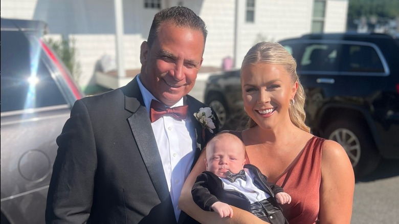 Nicholas Riccio and Karoline Leavitt holding a baby at a wedding