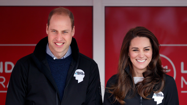 Prince William and Kate Middleton cheer at an event. 