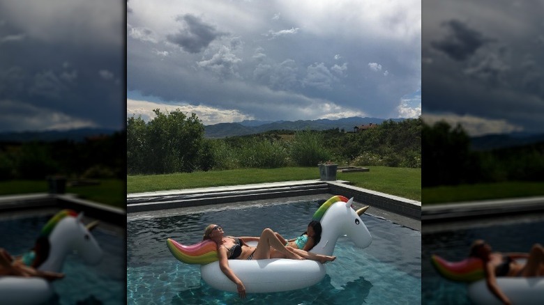 Katherine Heigl floating in a pool on a unicorn