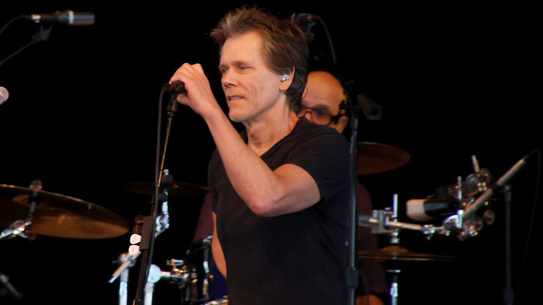 Kevin Bacon performing on stage as The Bacon Brothers