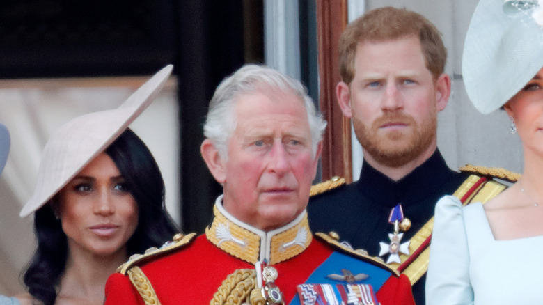 King Charles III, Prince Harry, and Meghan Markle posing 