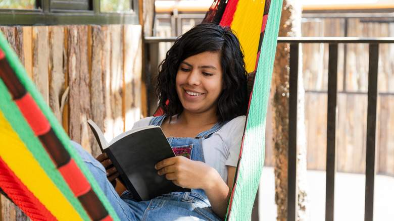 Mexican woman reading a book in a hammock