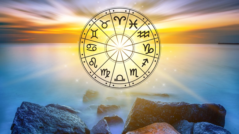 Zodiac wheel in front of sunset and water 