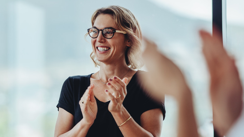 A woman smiling and clapping 