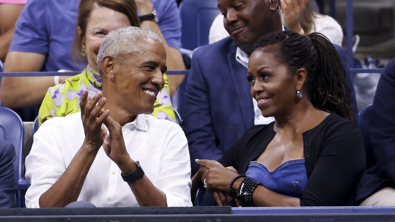 Barack Obama and Michelle Obama in bleachers smiling