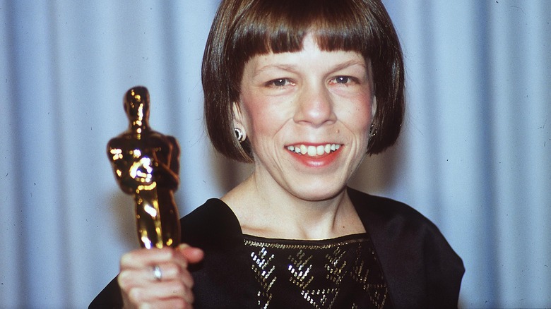 Linda Hunt holding up her Oscar