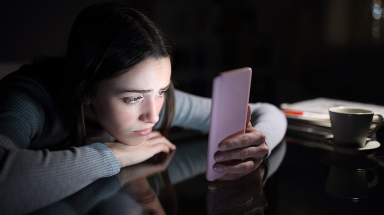 A sad girl checking her phone