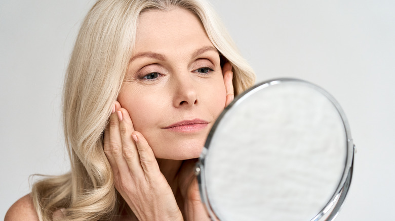 woman looking at skin mirror