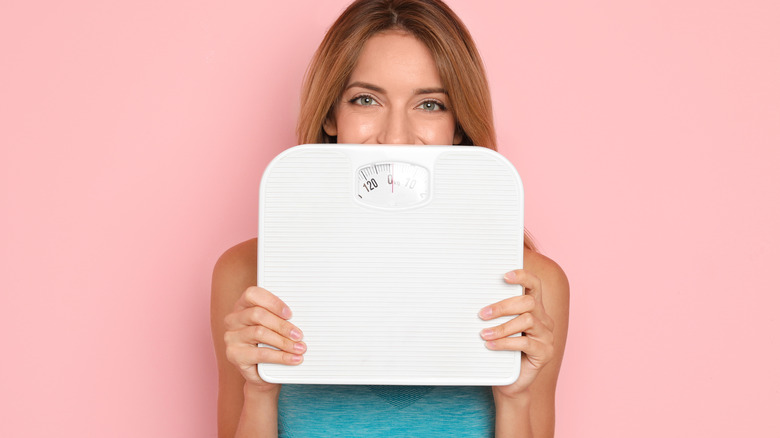 Woman holding a weighing scale