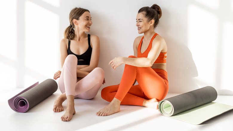 Two women with yoga mats