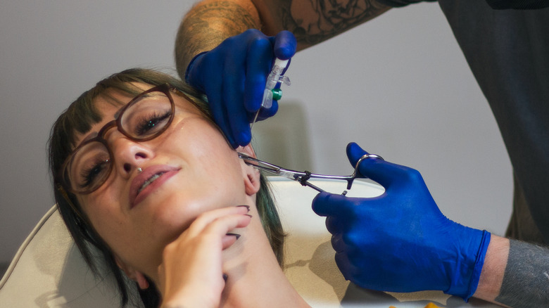 woman getting ear piercing