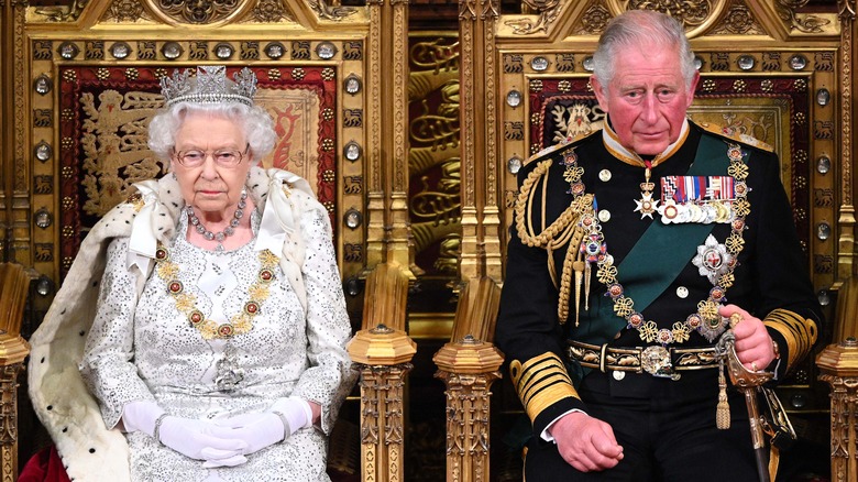 Queen Elizabeth and Prince Charles looking grumpy on thrones