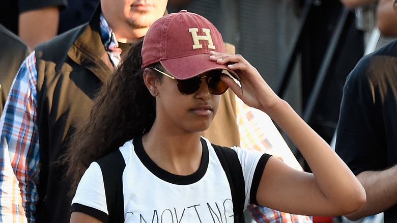 Malia Obama adjusting Harvard hat at music festival