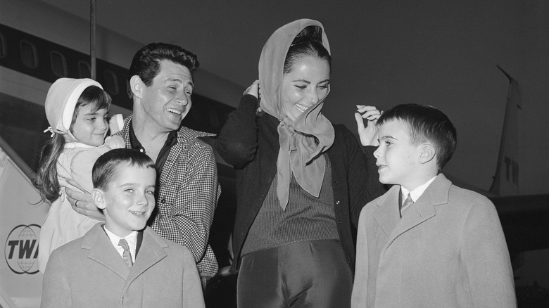 Elizabeth Taylor at the airport with her husband Fisher and three children