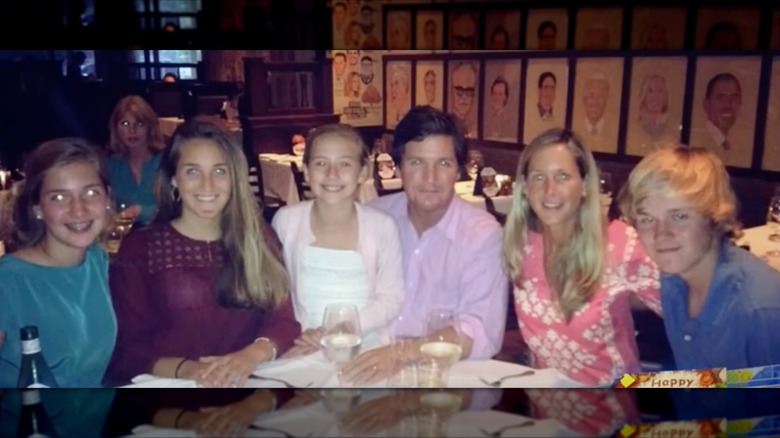 Tucker Carlson, his wife Susan, and his four young children seated together at a restaurant table.