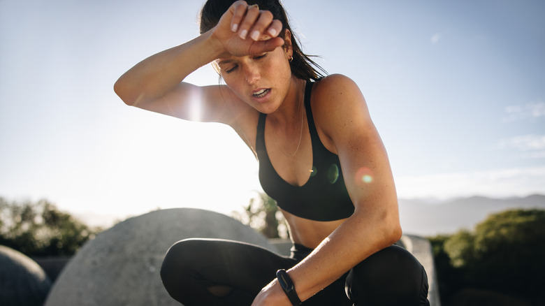 sweaty woman exhausted in workout clothes