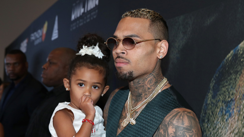 Chris Brown holds his daughter, Royalty, as she sucks her thumb