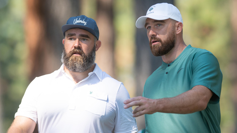 Jason Kelce and Travis Kelce talking while playing golf