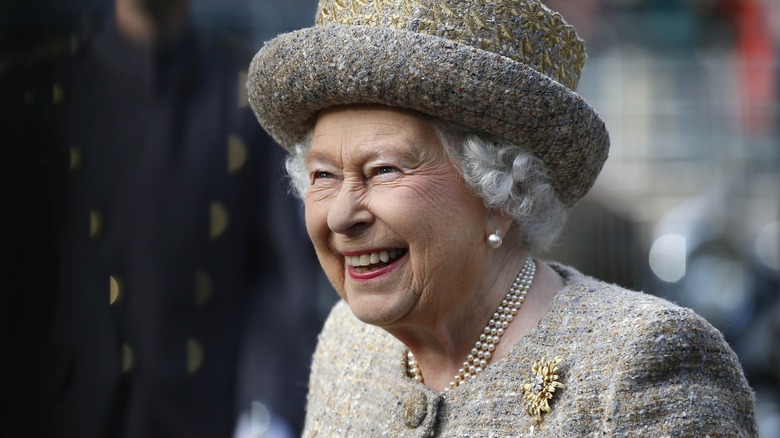 Queen Elizabeth II laughing in a hat