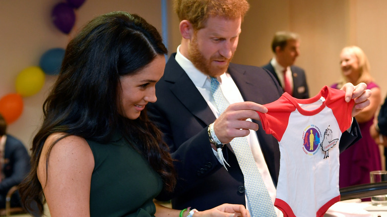 Meghan Markle and Prince Harry look at baby clothes