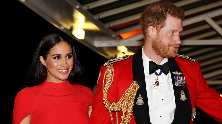 Meghan and Harry smiling in red