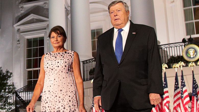 Amalija and Viktor Knavs walk in front of White House