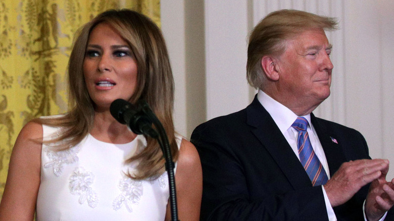 Melania Trump speaks at podium, Donald Trump stands next to her