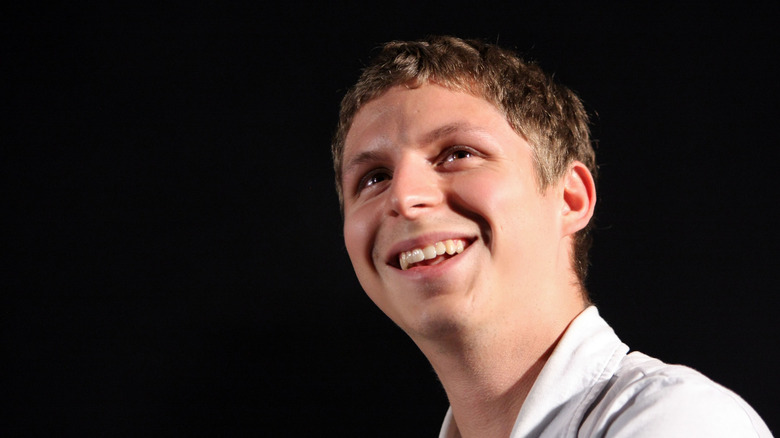 Michael Cera laughing  black background