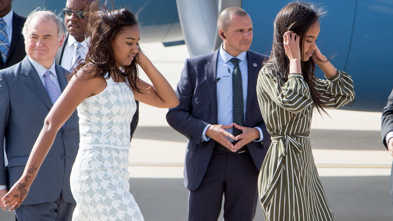 Sasha with henna tattoo walking with Malia Obama