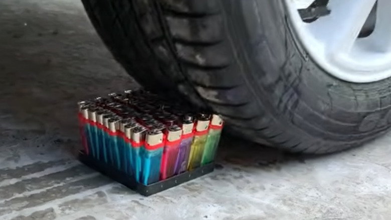 car tire driving over colorful plastic lighters