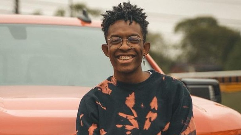 Breland smiling in front of a new truck