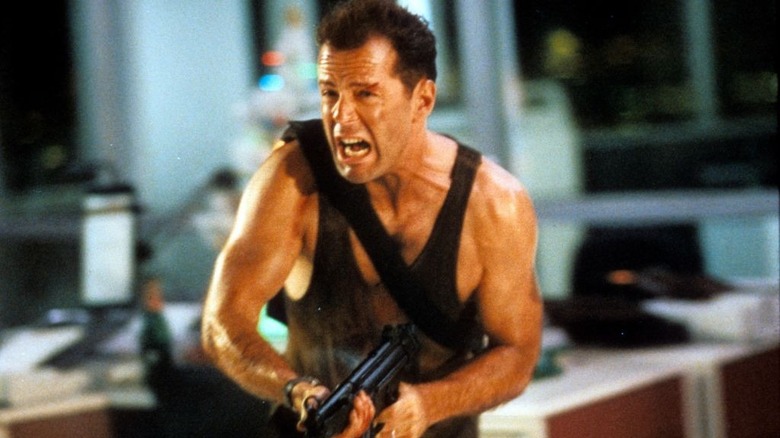 Bruce Willis running with automatic weapon in the movie "Die Hard"